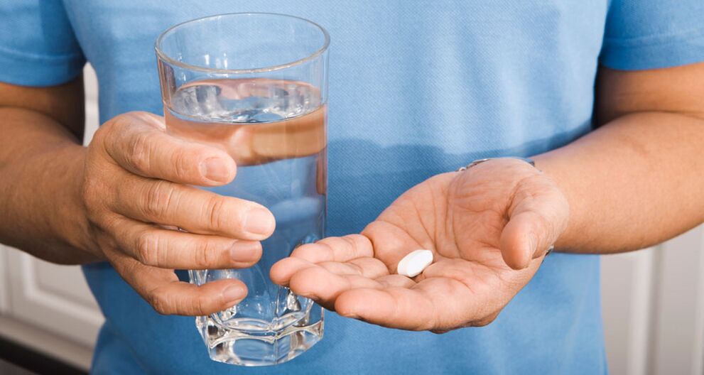 Een man neemt een vitaminecomplex om de potentie te verbeteren